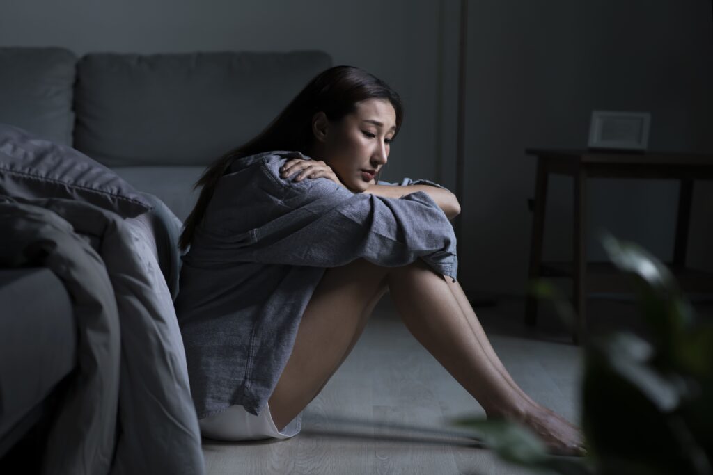 mujer deprimida sentada en el suelo tras post parto emocional