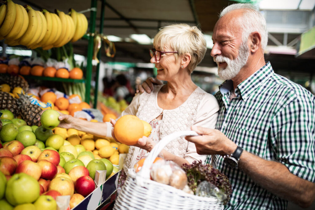 una pareja mayor comprando fruta para conseguir un envejecimiento activo y saludable