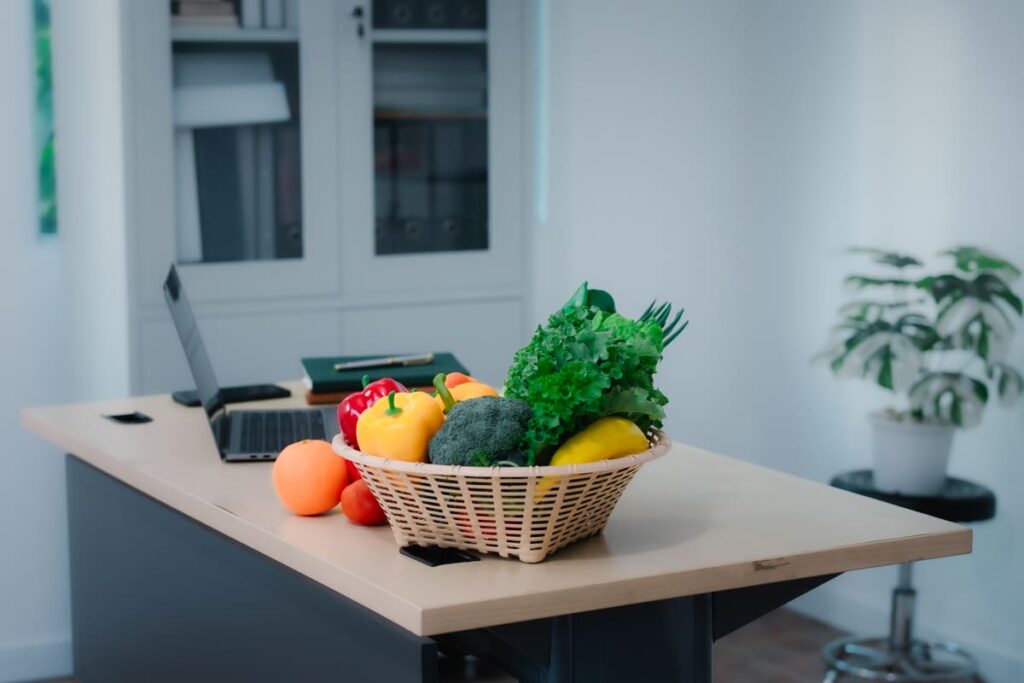 una cesta de frutas y verduras en un entorno de trabajo para alimentación saludable en el trabajo