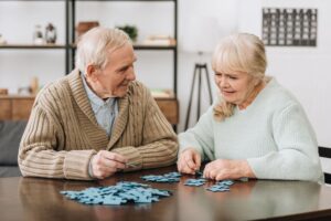una pareja de ancianos con un puzle de juegos de memoria para adultos