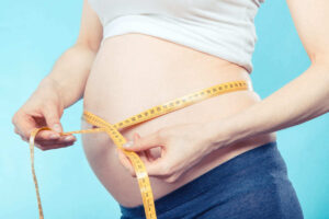 mujer midiéndose la barriga en el primer mes embarazo