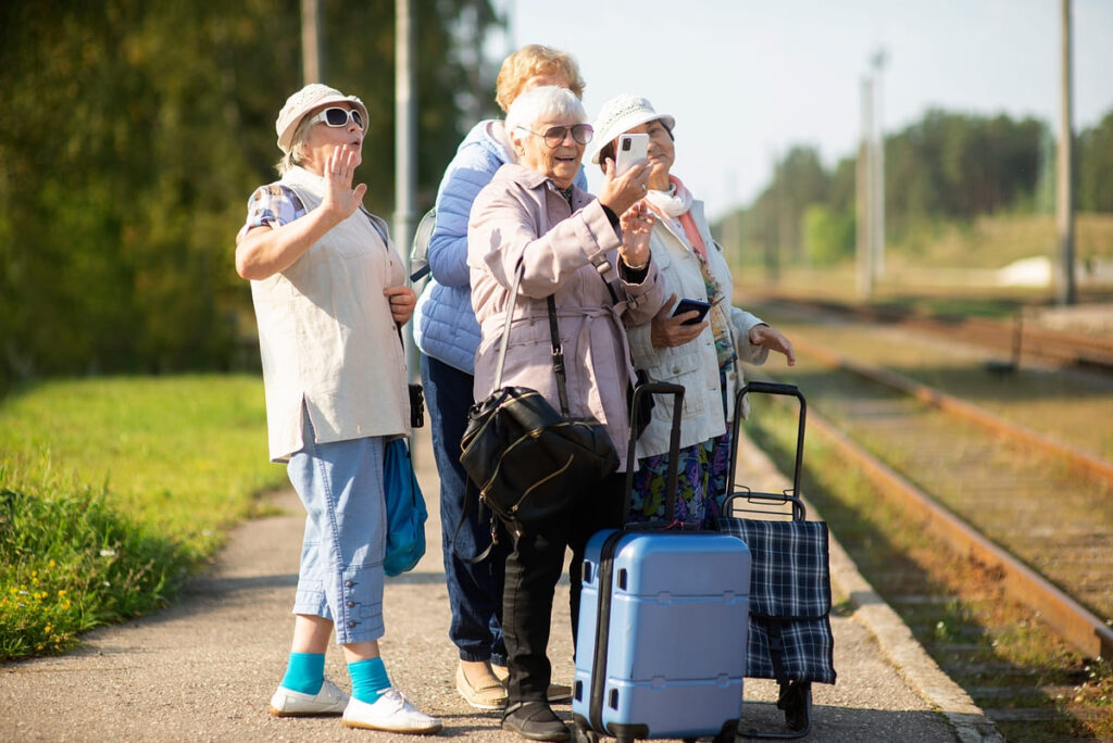 grupo de mujeres haciendo viajes para mayores de 65 años con las maletas esperando un tren