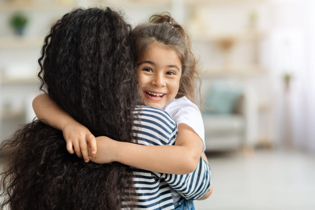 una niña abrazando a su madre tras adopción monoparental
