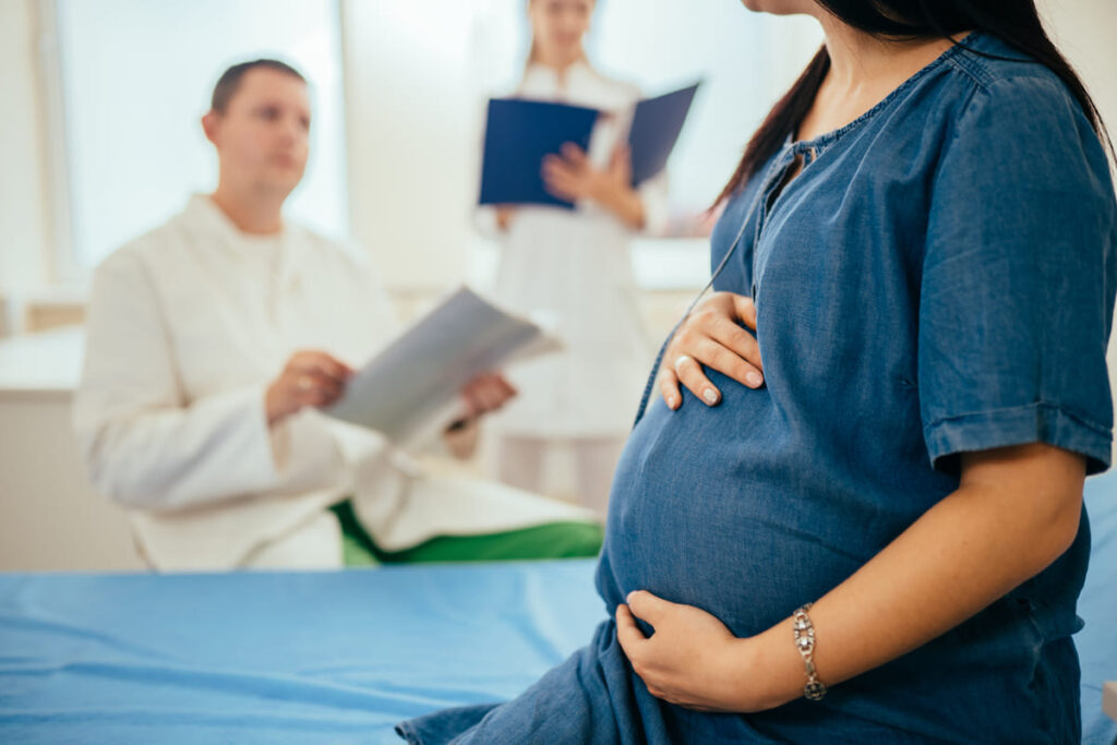 mujer embarazada en el médico preguntando hasta qué edad es recomendable tener hijos