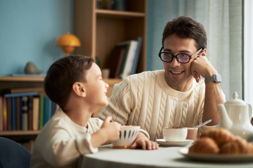 un padre hablando con su hijo en el desayuno explicando cómo se tienen hijos