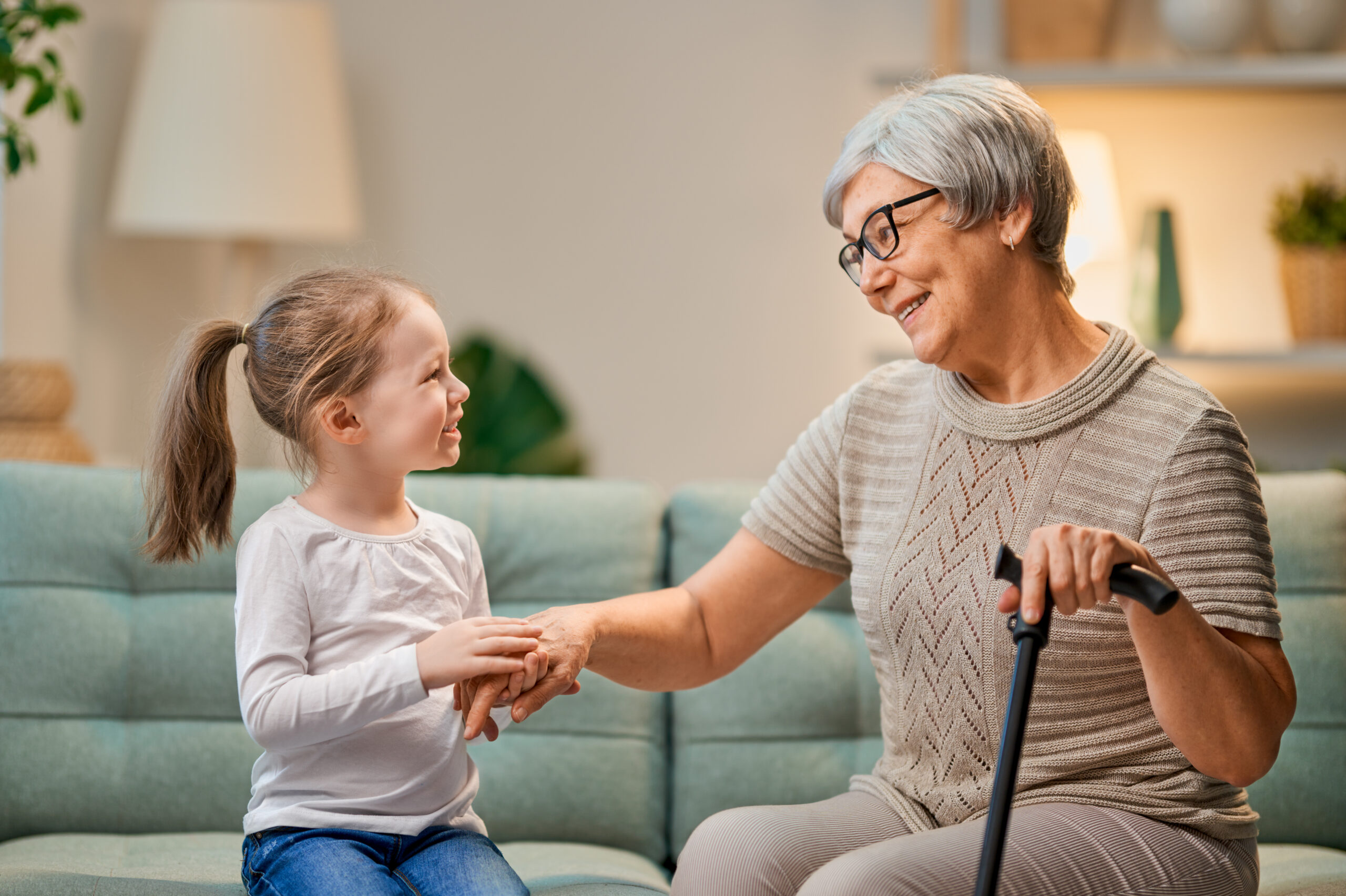 una niña y una mujer mayor dándose la mano representando el envejecimiento demográfico