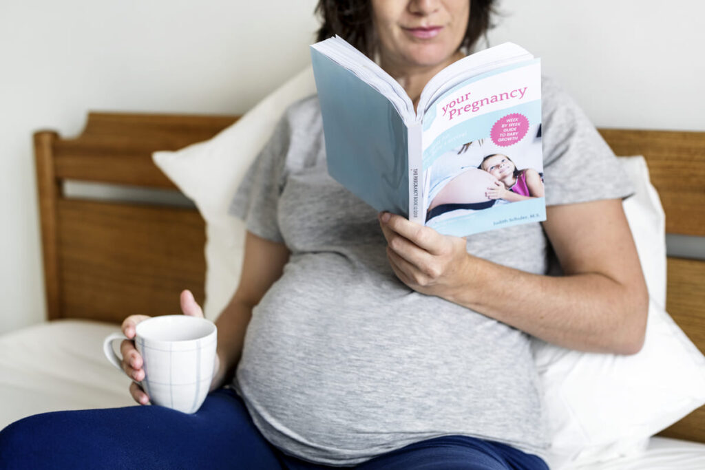 una mujer embarazada leyendo libros para embarazadas primerizas