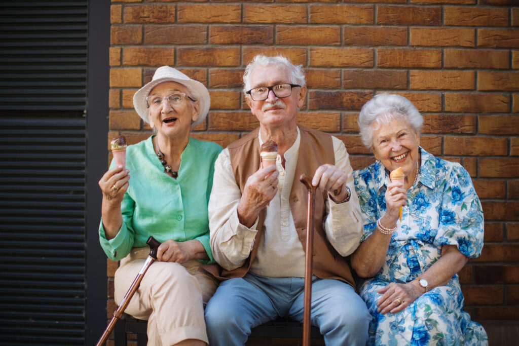 grupo de personas mayores comiendo helado mientras sonríen, envejecimiento demográfico